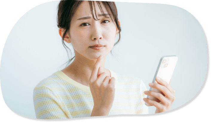 女性がスマホを片手に悩んでいる様子