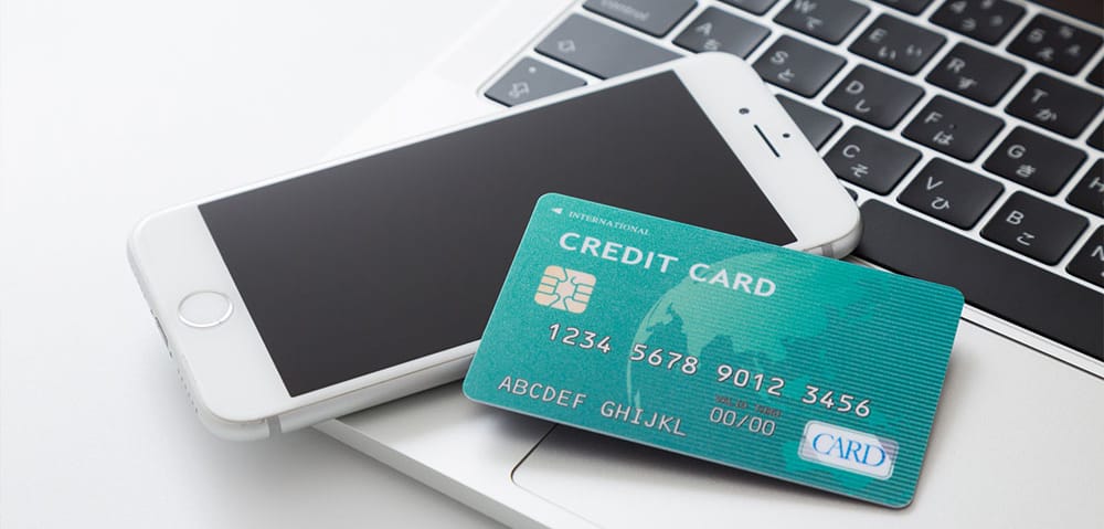 スマートフォンとPCとクレジットカードが並んだ写真